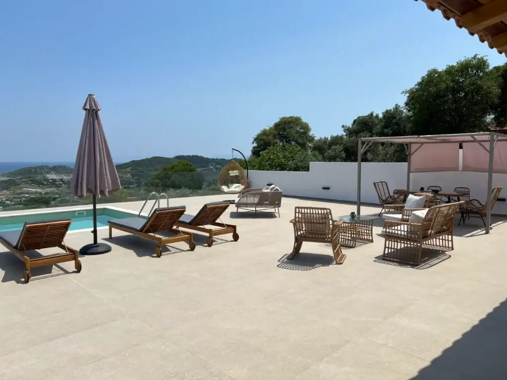 Private pool deck at Four Seasons Villas Skiathos in Kalivia with luxury sun loungers and scenic mountain views.